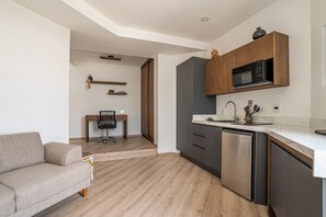 A modern kitchen with a built-in microwave, a dishwasher, and wooden cabinets. - Laurelian 2 · Aure · Private suite near downtown (Oaxaca de Juárez)