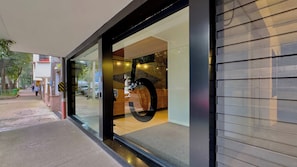 A modern building with a glass facade, a visible reception area, and a parking lot outside. - Sixth floor facing Parque España, Condesa (Mexico City)