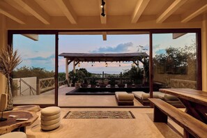 Eine großzügige Terrasse mit einer Pergola, Sitzgelegenheiten im Freien und Blick auf die Landschaft.