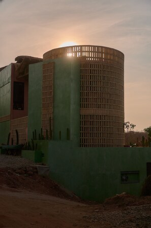 Un edificio con una struttura cilindrica e una sezione a tetto piatto.