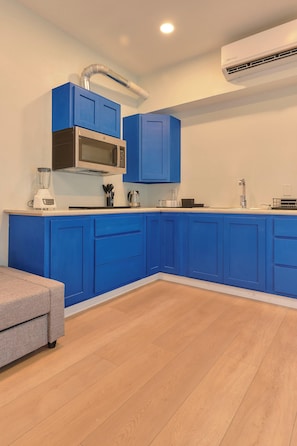 A modern kitchen with blue cabinets, a microwave, a blender, and a coffee maker. - Suite in La Punta, a minute from the sand (Puerto Escondido)
