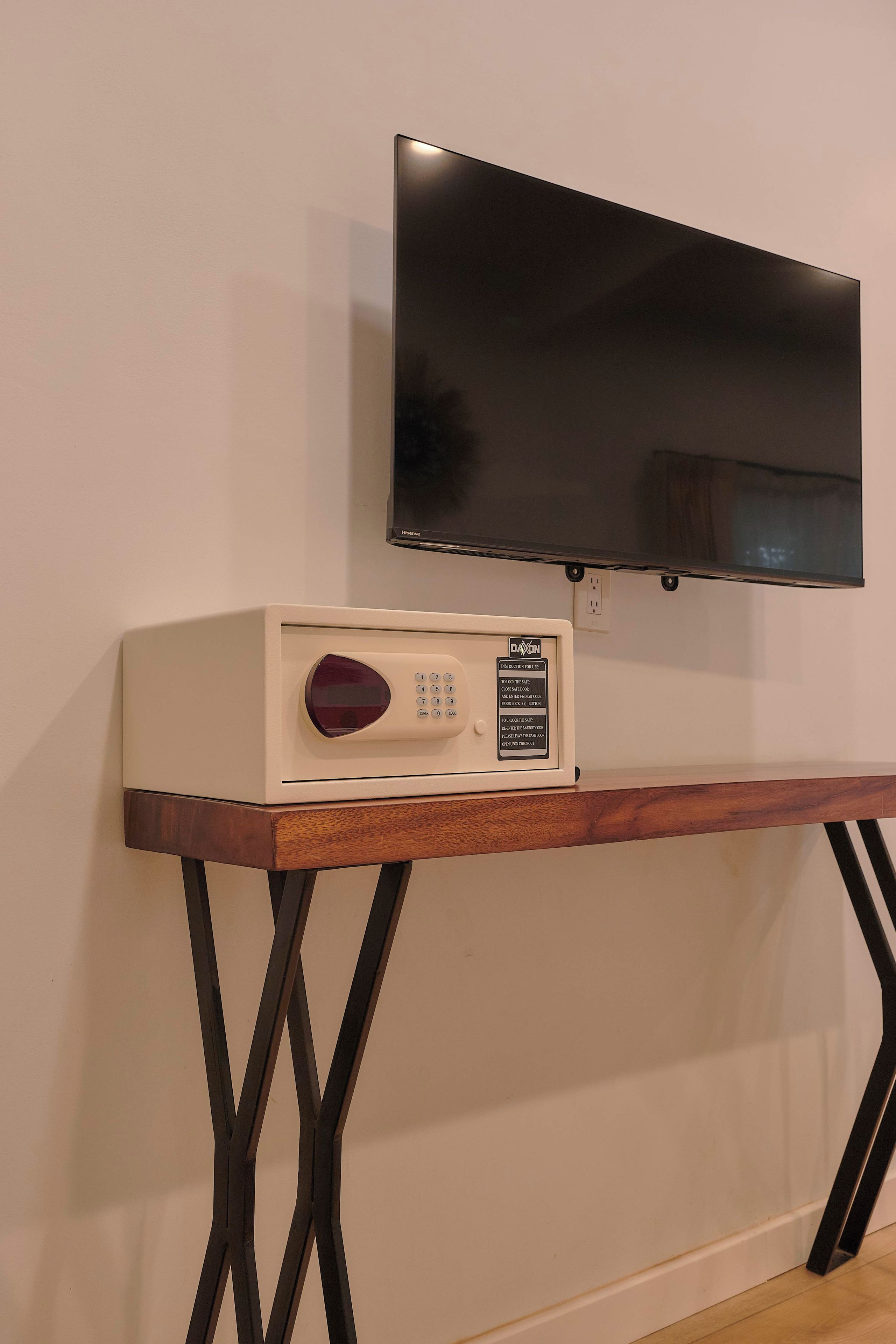 Ein Flachbildfernseher ist an einer Wand über einem Holzkonsolentisch mit einem Radio angebracht.