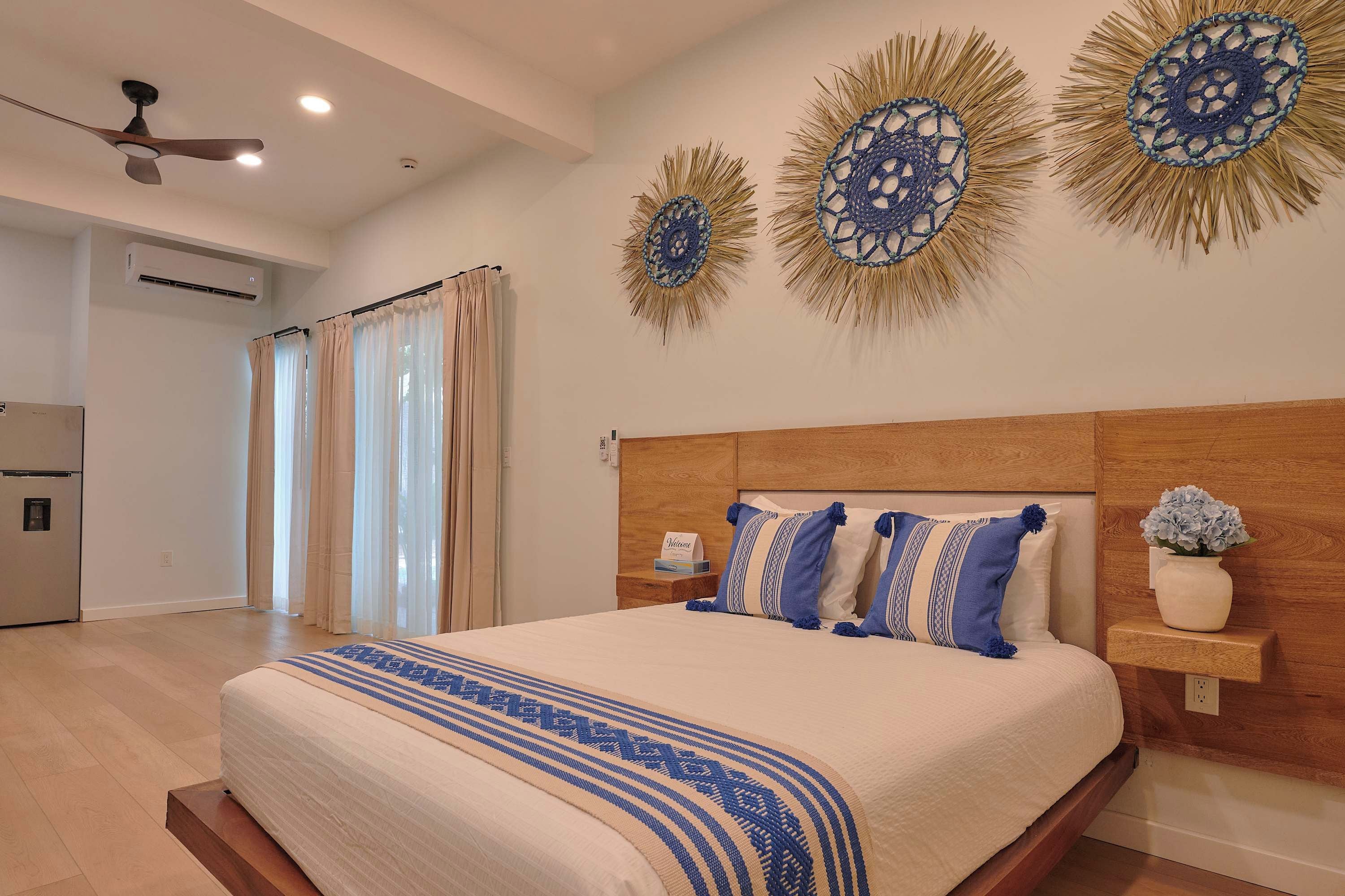 A bedroom with a large bed, a wooden headboard, a nightstand, and decorative wall art.