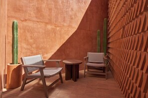 A room with two wooden chairs, a small round table, and a cactus in a pot. - Luxury Boutique Hotel in Downtown Oaxaca (Oaxaca de Juárez)