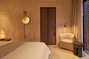 A hotel room with a bed, a chair, a lamp, and a door. - Luxury Boutique Hotel Near Downtown Oaxaca (Oaxaca de Juárez)