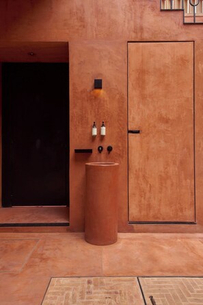 A restroom with a large, round sink, two soap dispensers, and a black door. - Luxury Boutique Hotel Near Downtown Oaxaca (Oaxaca de Juárez)