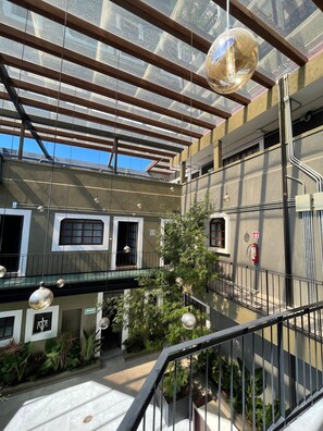 A multi-level building with a glass ceiling, outdoor plants, and a fire extinguisher.