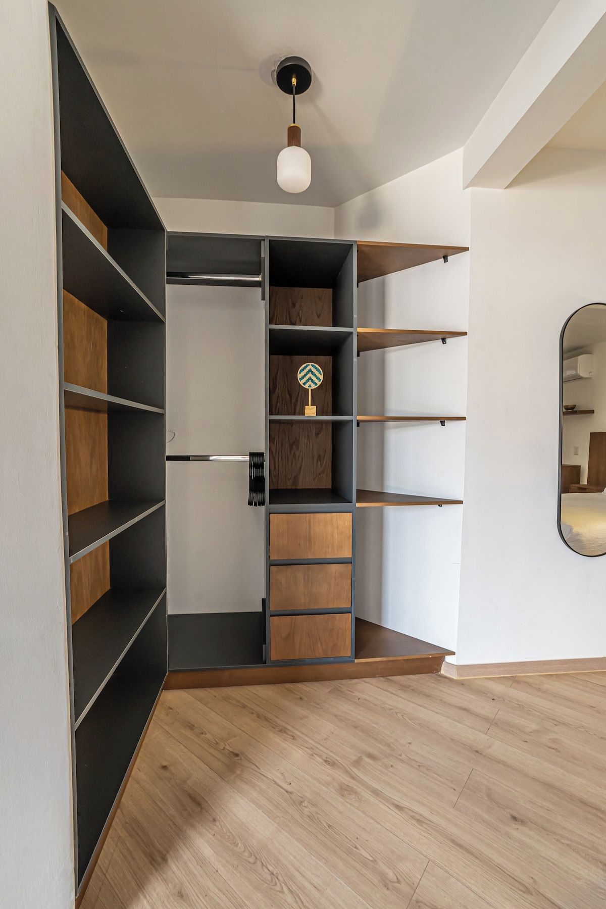 Een moderne kast met verschillende vakken en een hanglamp.