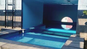 Ein Schwimmbecken mit einer Leiter und einem Rundfenster.
