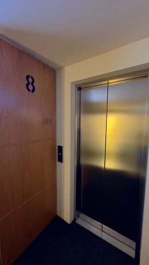 An elevator with a metallic finish and a control panel on the wall. - Eighth floor facing Parque España, Condesa (Ciudad de México)