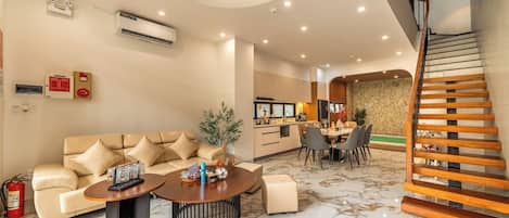 A modern living room with a sofa, coffee table, and dining area.