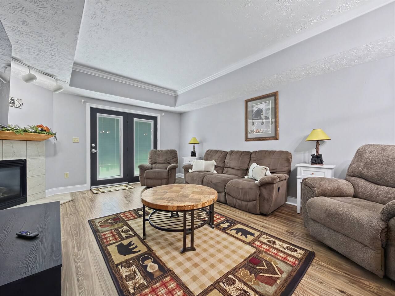 A living room with a fireplace, a round coffee table, a sofa, and a television.