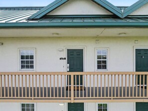 A building with a balcony, a green door, and a number '1902' sign. - The Fairway Retreat | Golf Course Views | Pool & Spa | Dollywood (Pigeon Forge)