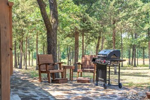 A wooden deck with a barbecue grill, two wooden chairs, and a small table. - 3rd nt free!Sleeps 11 Comfortably, Group Retreat, Hot Tub, Pedal Boat and Kayaks (Edgewood)