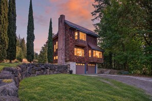 Ein zweistöckiges Haus mit einer Steinmauer und einer Garage.