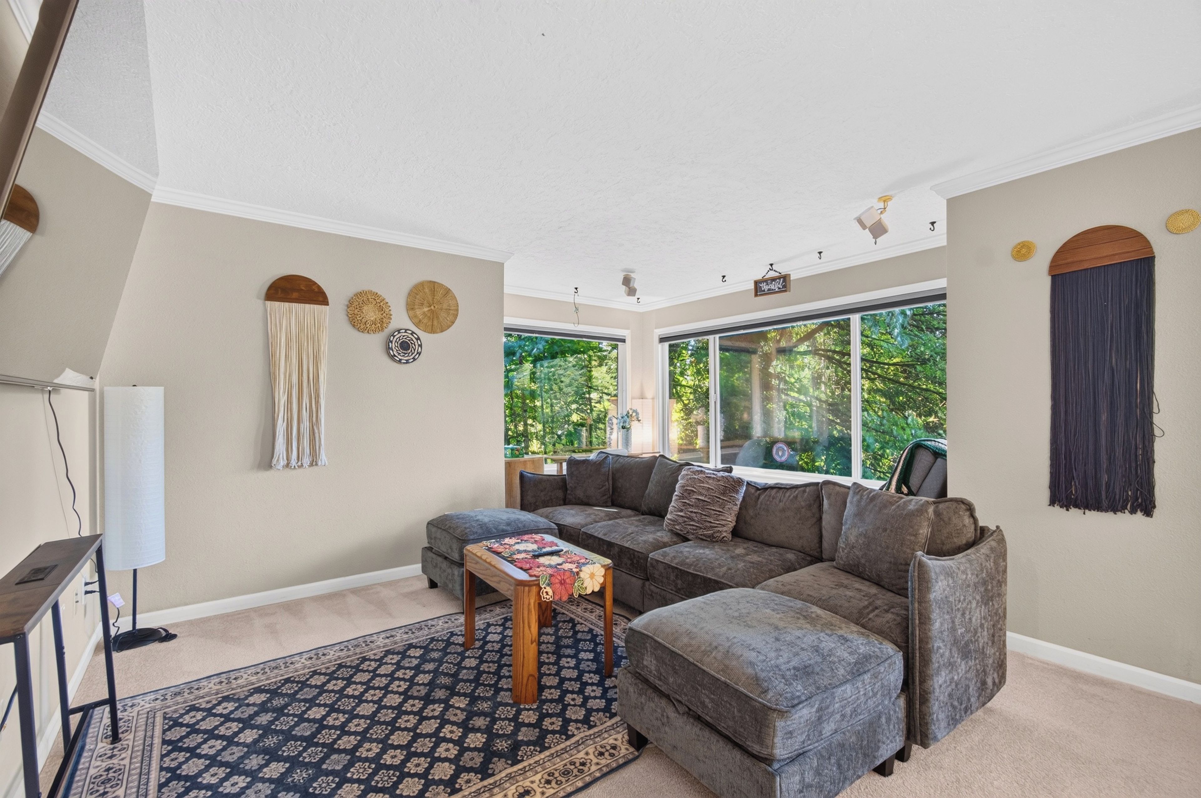A living room with a sectional sofa, a small table, and a patterned rug.