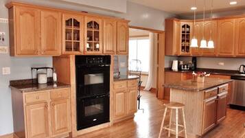 A kitchen with wooden cabinets, a black oven, and a granite countertop.