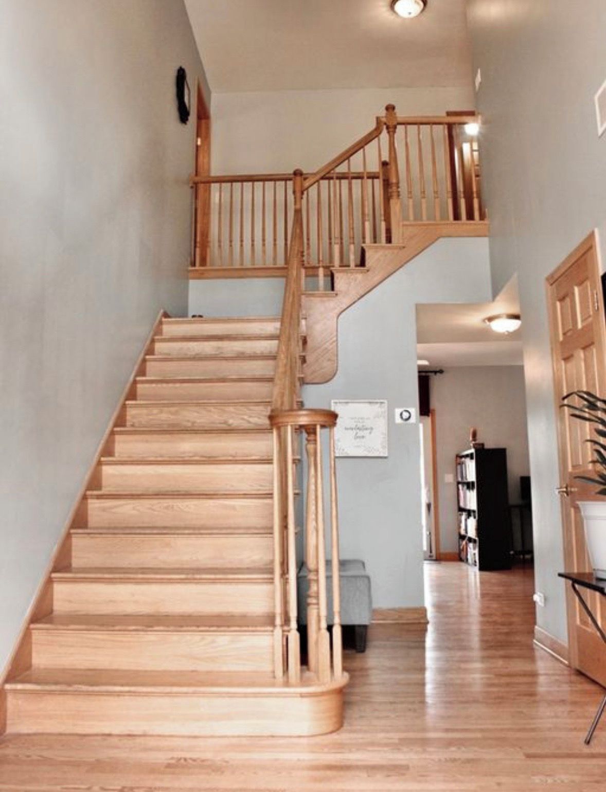 A wooden staircase with a handrail leading to an upper floor.