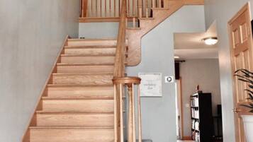A wooden staircase with a handrail leading to an upper floor.