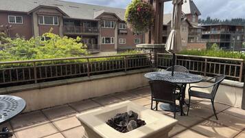 A patio area with a fire pit, outdoor furniture, and a hanging flower basket.