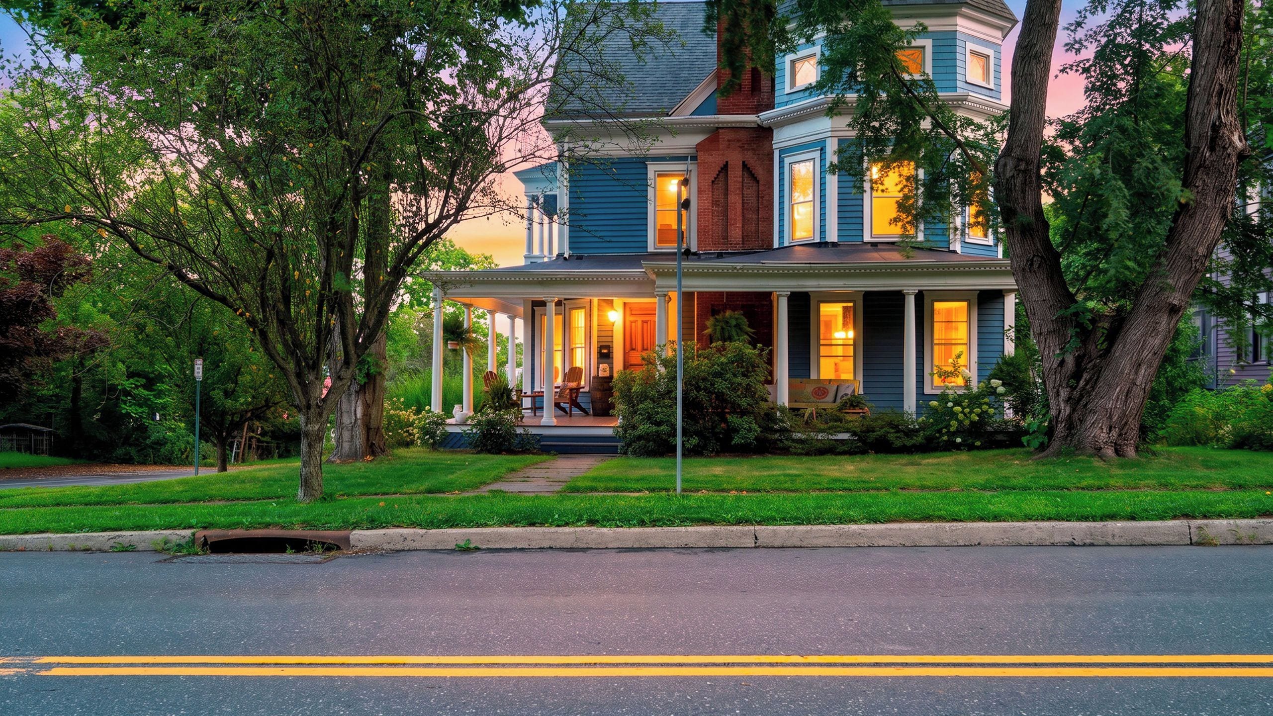 A two-story house with a porch and a well-maintained lawn.