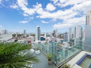 A high-rise building with a glass balcony overlooking a cityscape.