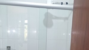 A bathroom with a glass-enclosed shower, a white toilet, and a wooden door. - Vacation home in Serra Negra, upscale and very quiet neighborhood. (Serra Negra)