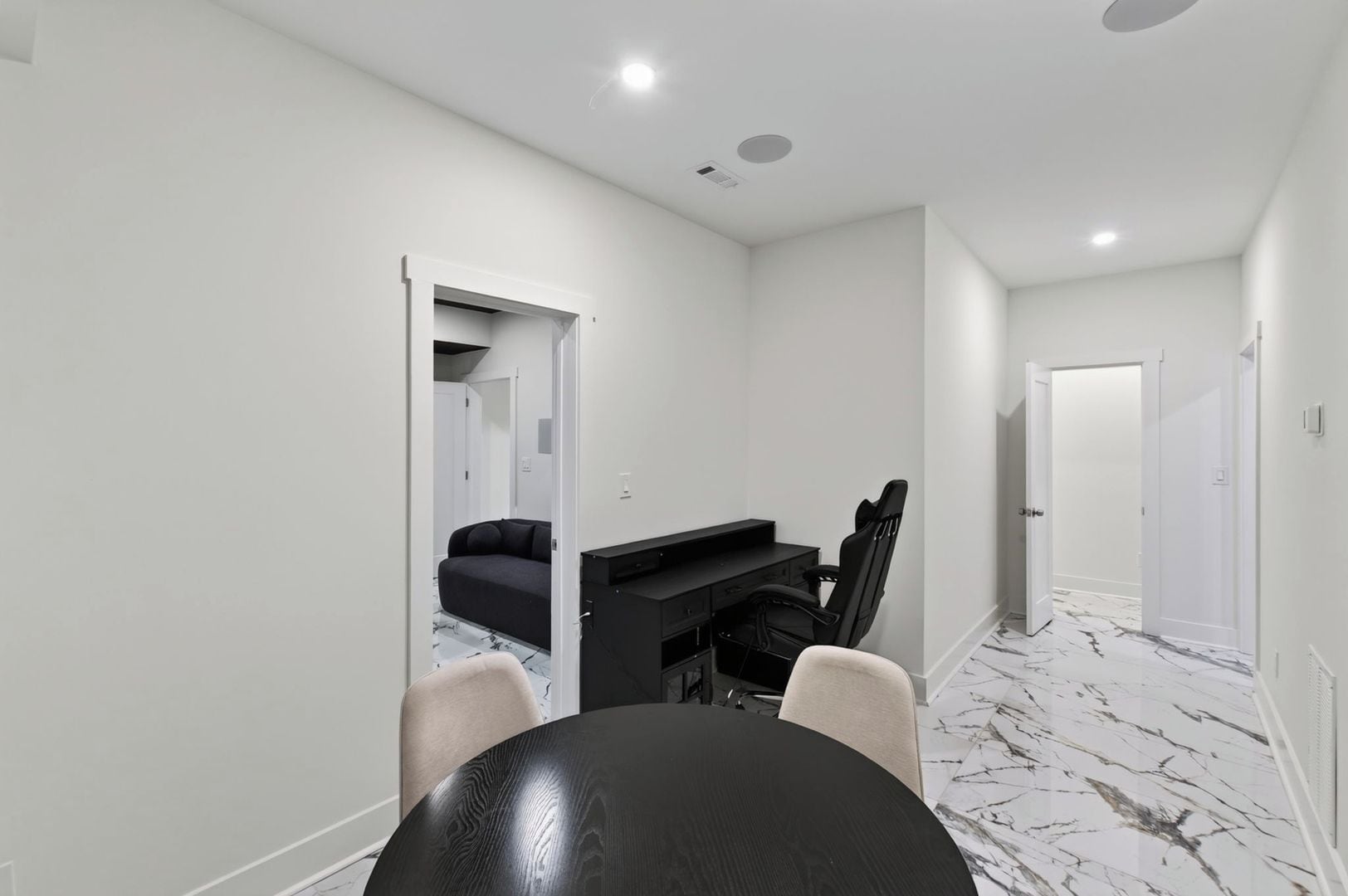 A modern interior with a dining table, chairs, a sofa, and a TV stand.