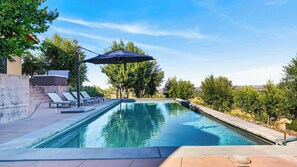 A swimming pool with lounge chairs and an umbrella, surrounded by trees and a clear sky. - The Villa at Ambyth Estate by Avantstay Pool + Hot Tub + Snooker 42-acre Organic Vineyard (Templeton)