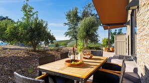 An outdoor dining area with a table set for two, a bottle of wine, and a bowl of grapes. - The Villa at Ambyth Estate by Avantstay Pool + Hot Tub + Snooker 42-acre Organic Vineyard (Templeton)