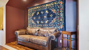 A brown leather sofa in a room with a wooden floor and a dark blue floral tapestry on the wall. - The Villa at Ambyth Estate by Avantstay Pool + Hot Tub + Snooker 42-acre Organic Vineyard (Templeton)