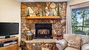 A living room with a stone fireplace, a television, and a leather sofa. - Ski Casa Azul by Avantstay Ski Shuttle + Walk to Main St Shared Hot Tub + Grill (Breckenridge)