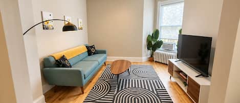 A modern living room with a sofa, coffee table, and TV.