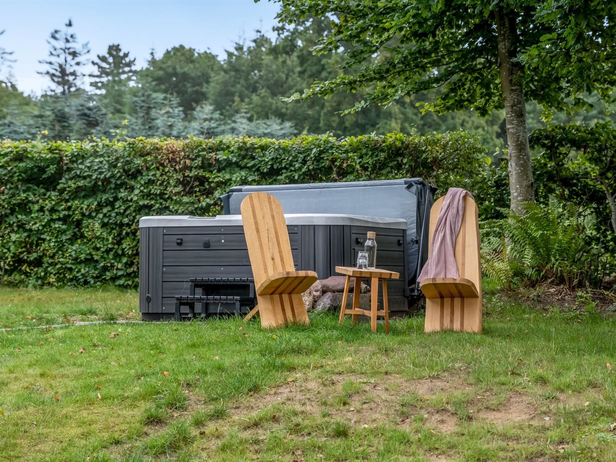 A portable outdoor grill with a table and chairs in a grassy area.