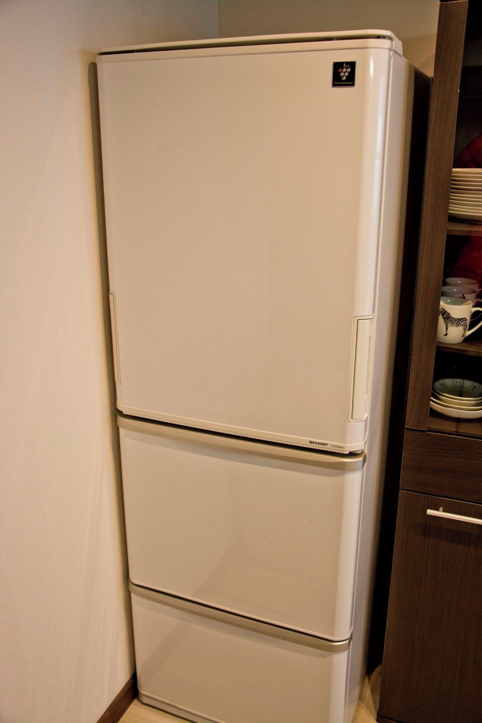 A white refrigerator with a control panel on the top.