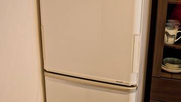 A white refrigerator with a control panel on the top.