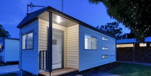 A small, single-story mobile home with a front door and a small porch.