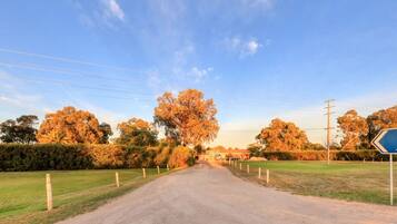 Eine ländliche Straße, die zum Swan Hill Holiday Park führt, mit einem Wegweiser.