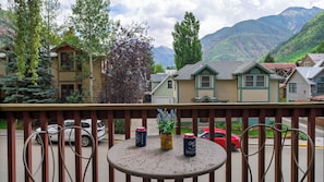A balcony with a table, chairs, and a view of houses and mountains. - Canyon Light by Avantstay Private Sauna + Mountain-view Balcony Steps to Free Gondola & Main St (Telluride)