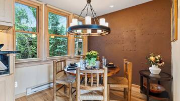 A dining area with a wooden table, chairs, and a chandelier.