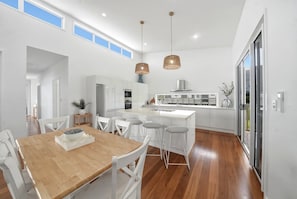 Una cocina moderna con armarios blancos, una isla central e iluminación colgante.