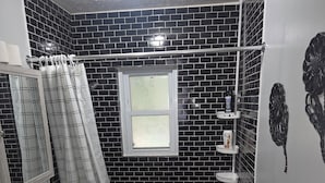 A bathroom with a bathtub, toilet, and a shower curtain. - Yellow Mellow sleeps 4  (Jackson)