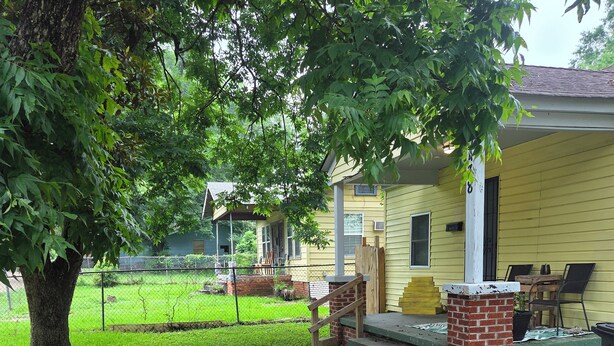 A residential property with a yard, a tree, a brick planter, and a house with a porch. - Yellow Mellow sleeps 4  (Jackson)