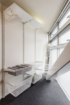 Una habitación moderna con literas, cestas de almacenamiento y una ventana con persianas.