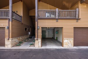 Eine Blockhütte mit Veranda, Stein Fundament und einer Garage.