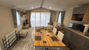 Un espacio habitable compacto con kitchenette, comedor y zona de estar con vistas.