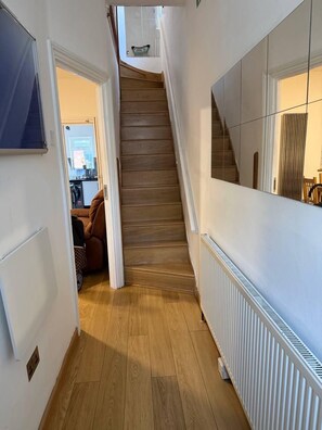 A staircase leading to a second floor with a kitchen area visible at the bottom.