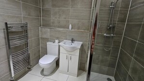 Un baño moderno con inodoro, lavabo y ducha.