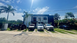 Un edificio moderno de dos pisos con un estacionamiento en la parte delantera.