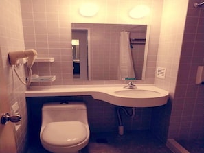 A compact bathroom with a toilet, sink, and a mirror above the sink. - Jinjiang Inn (Fuzhou)